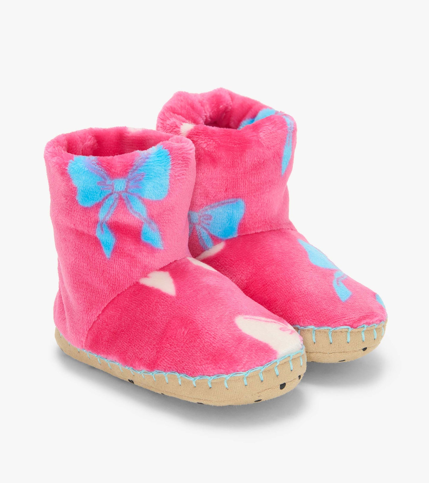 Pair of pink fleece bootie slippers with blue bow print and tan soles, shown from the front