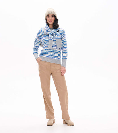 Model wearing blue ombre patterned sweater with gray trim and matching scarf tied at the neck