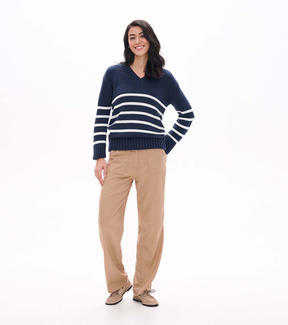 Full front view of navy V-neck sweater with cream stripes styled with tan pants