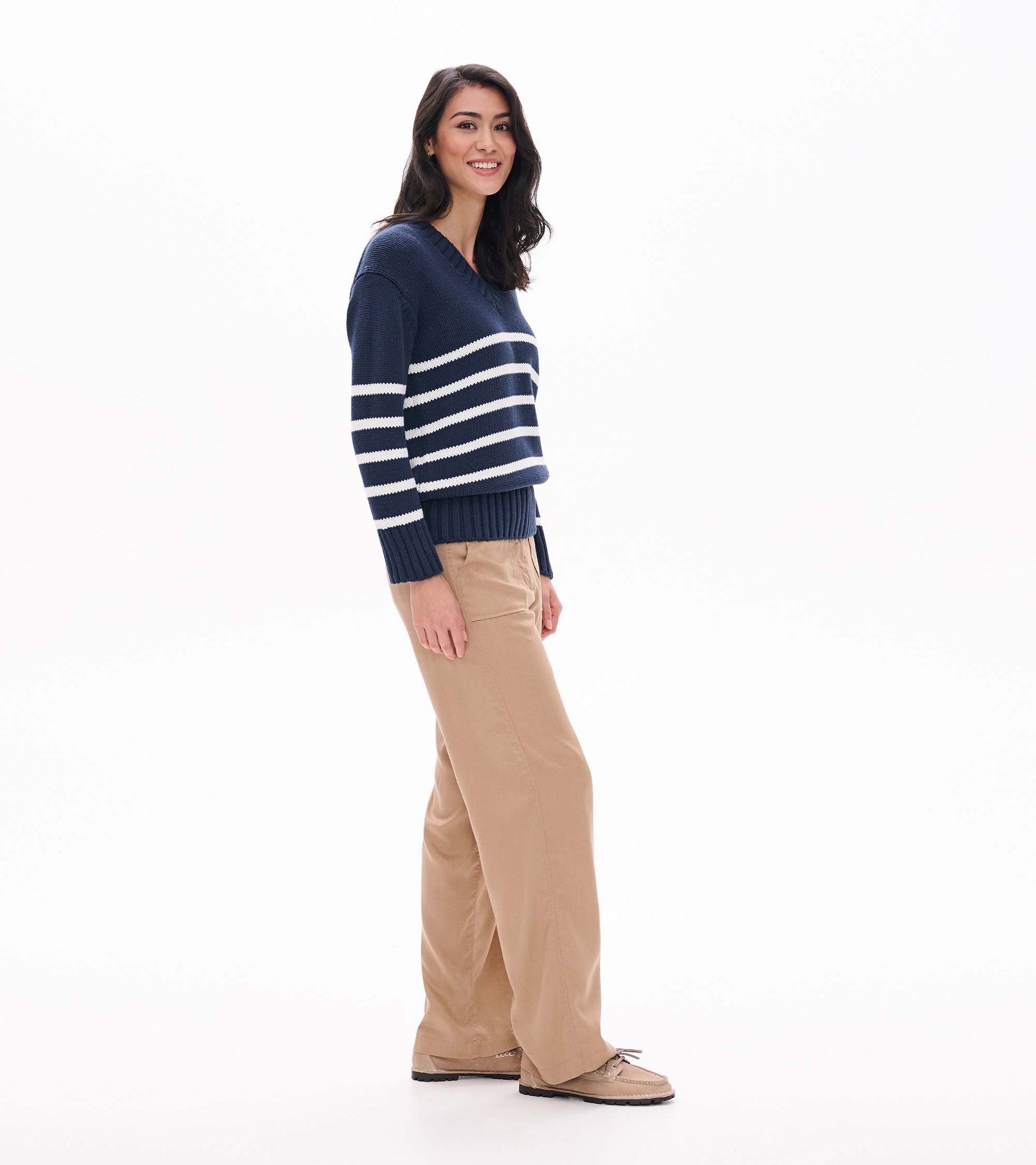 Side view of navy V-neck sweater with cream stripes and long ribbed cuffs