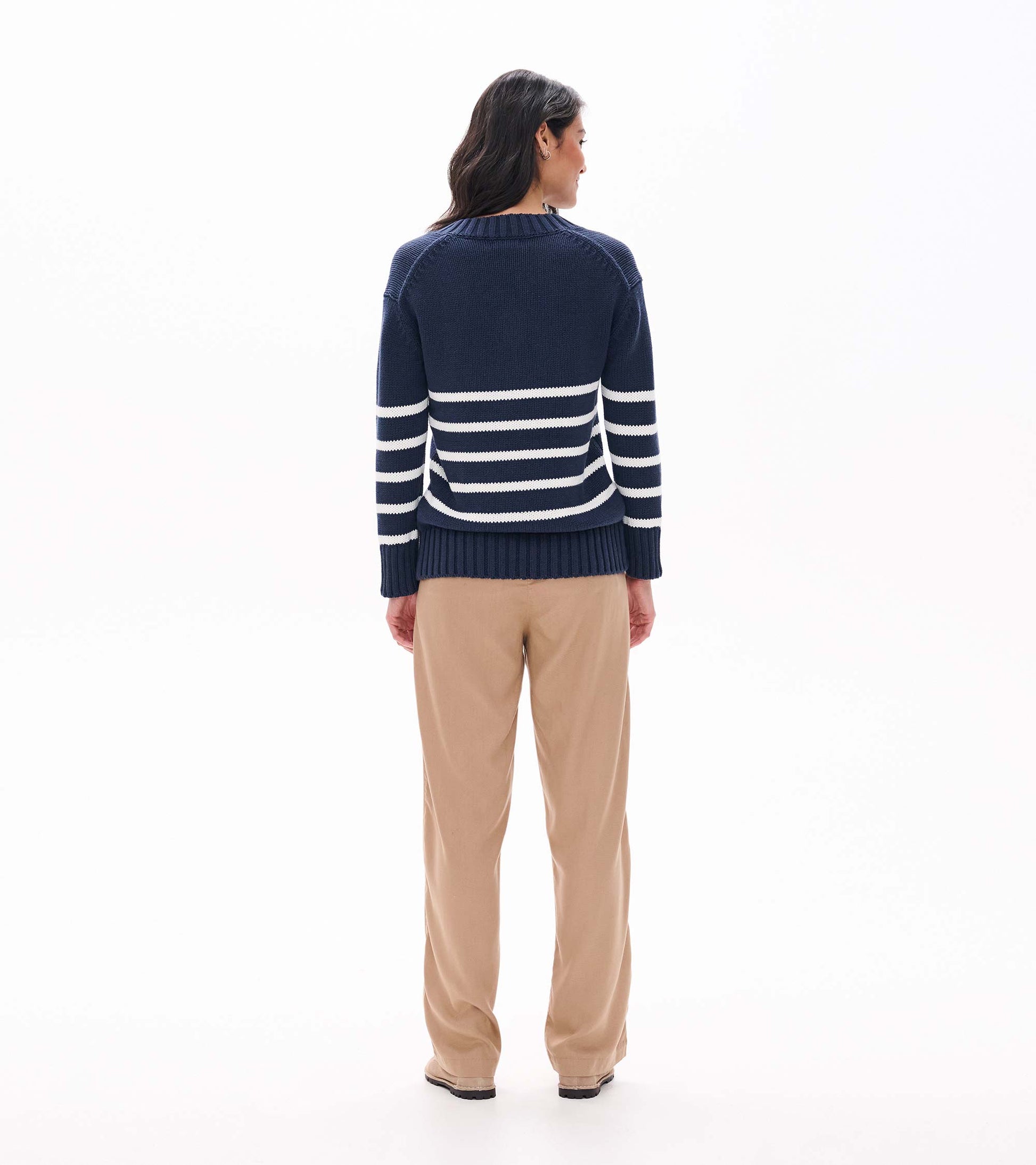 Back view of navy sweater with cream stripes across the lower back and sleeves