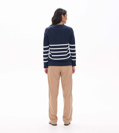 Back view of navy sweater with cream stripes across the lower back and sleeves