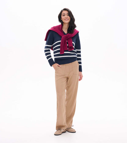 Front view of navy V-neck sweater with cream stripes, shown on model with tan pants