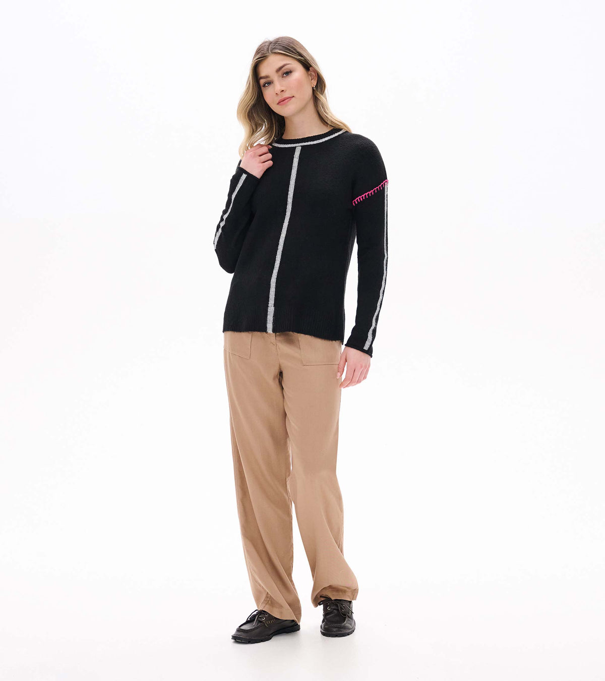 Maeve black sweater styled on model, full front view with grey stripes and pink shoulder stitching