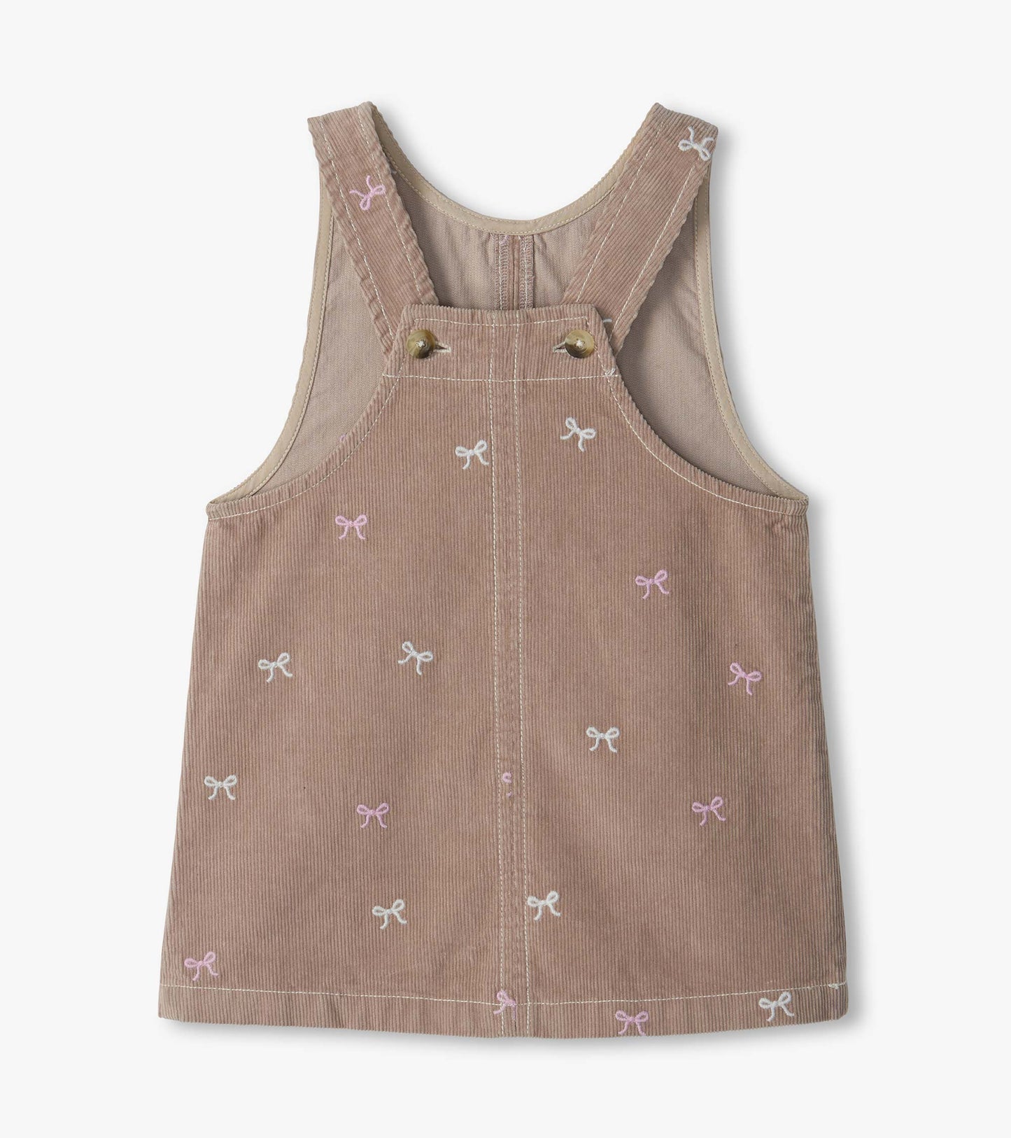 Back view of a dusty pink pinafore dress with crossed straps, button detail, and bow embroidery