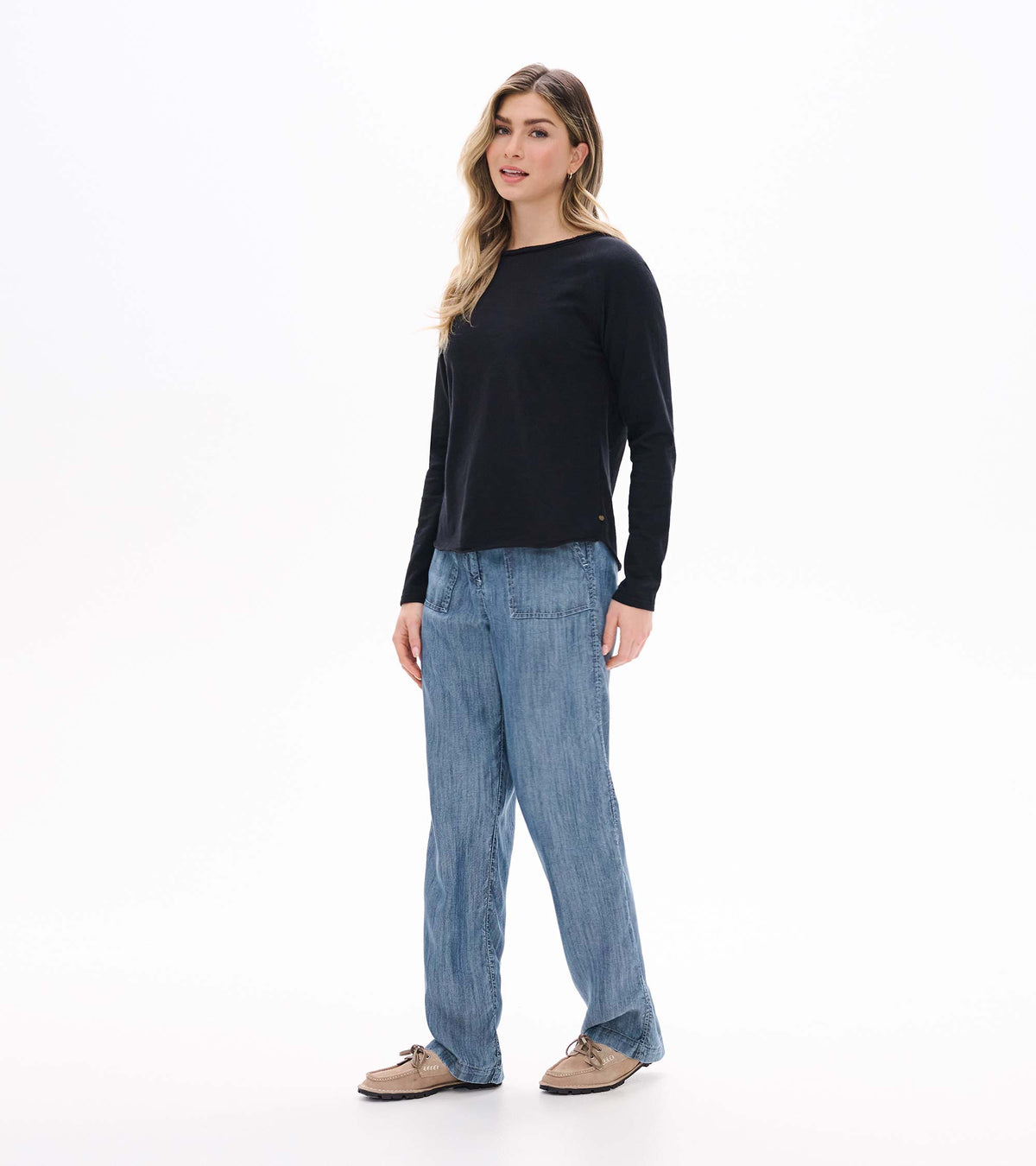 Front angled view of black raglan sleeve tee on model with long sleeves and relaxed silhouette