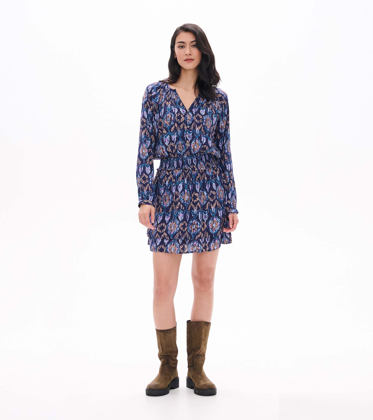 Front view of mini dress with long sleeves, smocked waist, tiered skirt and blue, purple and tan ikat print