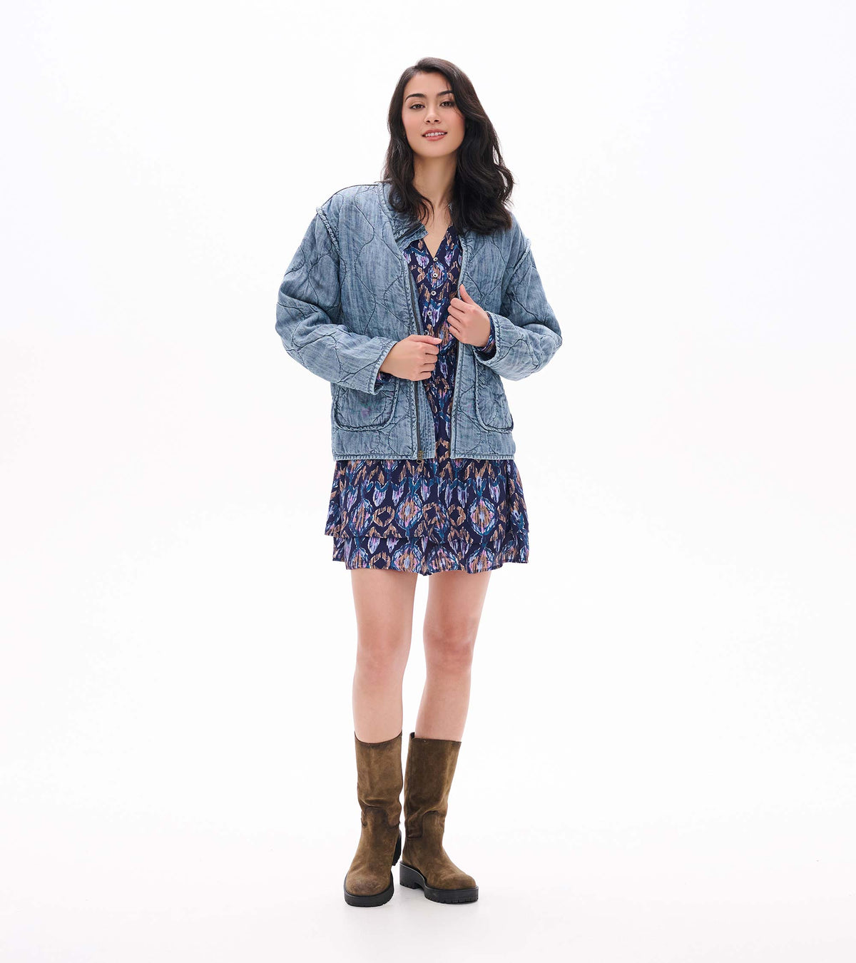 Front view of textured ikat mini dress styled with a light blue quilted jacket and brown boots