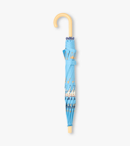 Closed blue umbrella with dog print, curved pale handle, and matching wrap strap