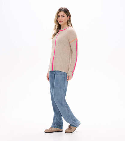 Side view of oatmeal sweater with neon pink trim and sleeve stripe on model