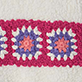 View Girls Fuzzy Crochet Pullover White fuzzy knit swatch with a horizontal band of red crochet squares featuring pink and blue floral centers
