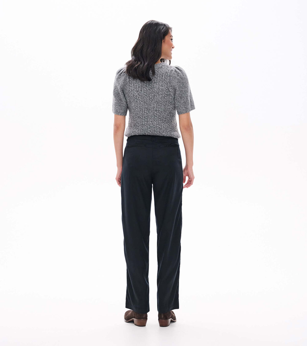 Back view of black wide-leg pants styled with a gray short-sleeve sweater and ankle boots