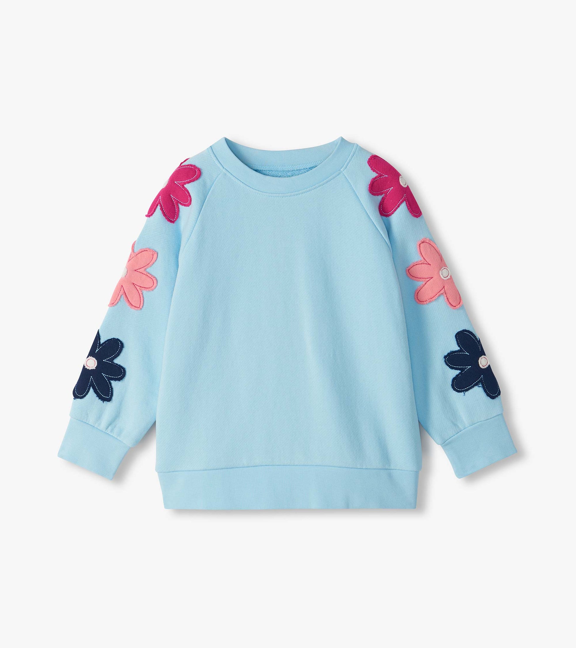 Light blue slouchy pullover with raglan sleeves and large pink and navy flower appliqués on the sleeves