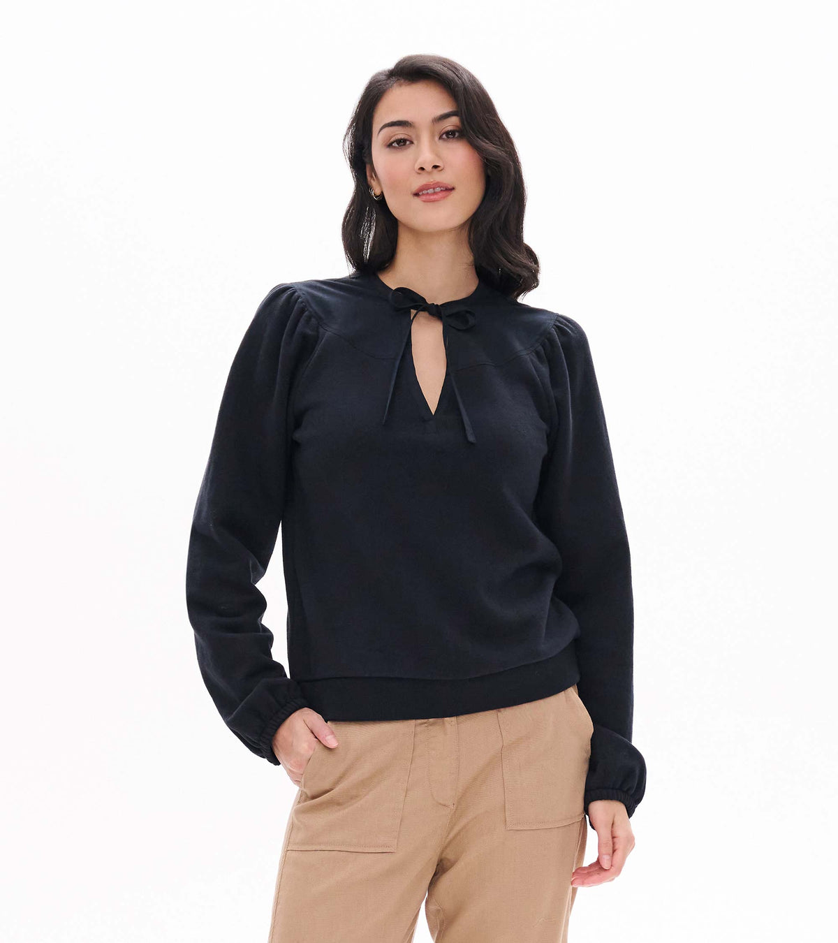 Black long sleeve top with tie neckline, puffed shoulders, and banded hem, shown on model
