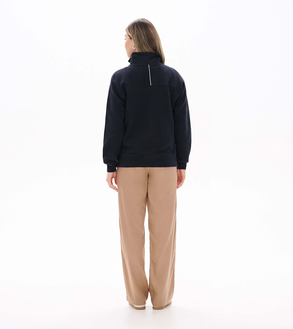 Back view of black 1/4 zip knit top with stand collar and vertical white detail below the collar
