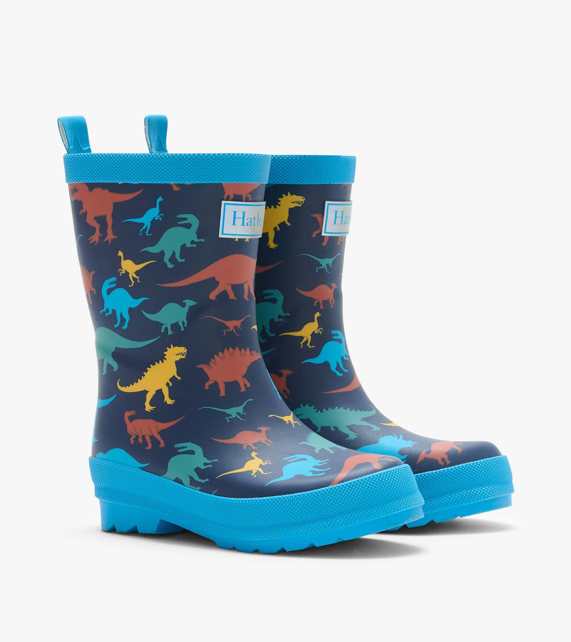 Pair of navy kids rain boots with colorful dinosaur print and bright blue trim, front three-quarter view