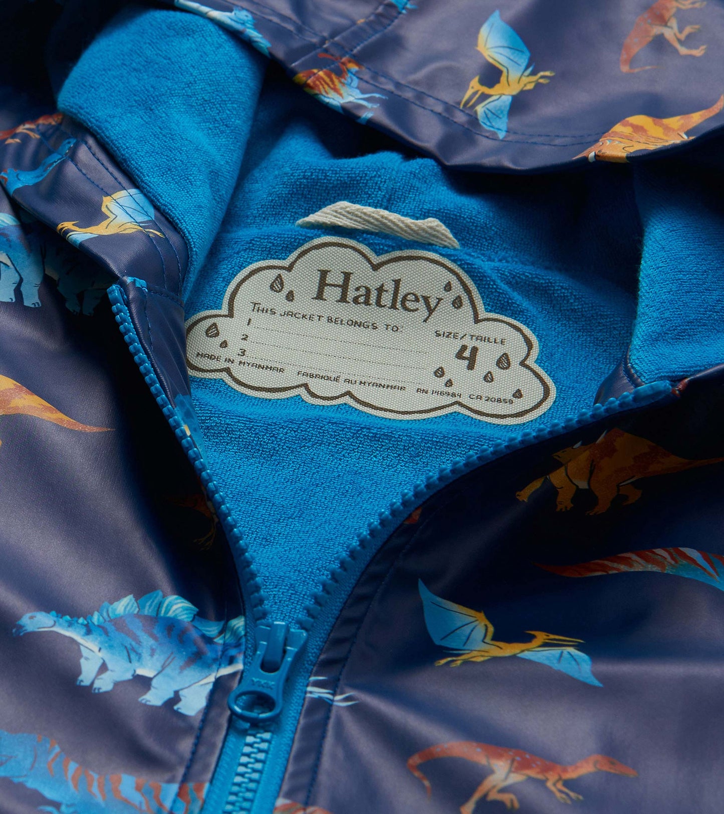 Close-up of rain coat interior with bright blue lining, zipper, and visible Hatley neck label