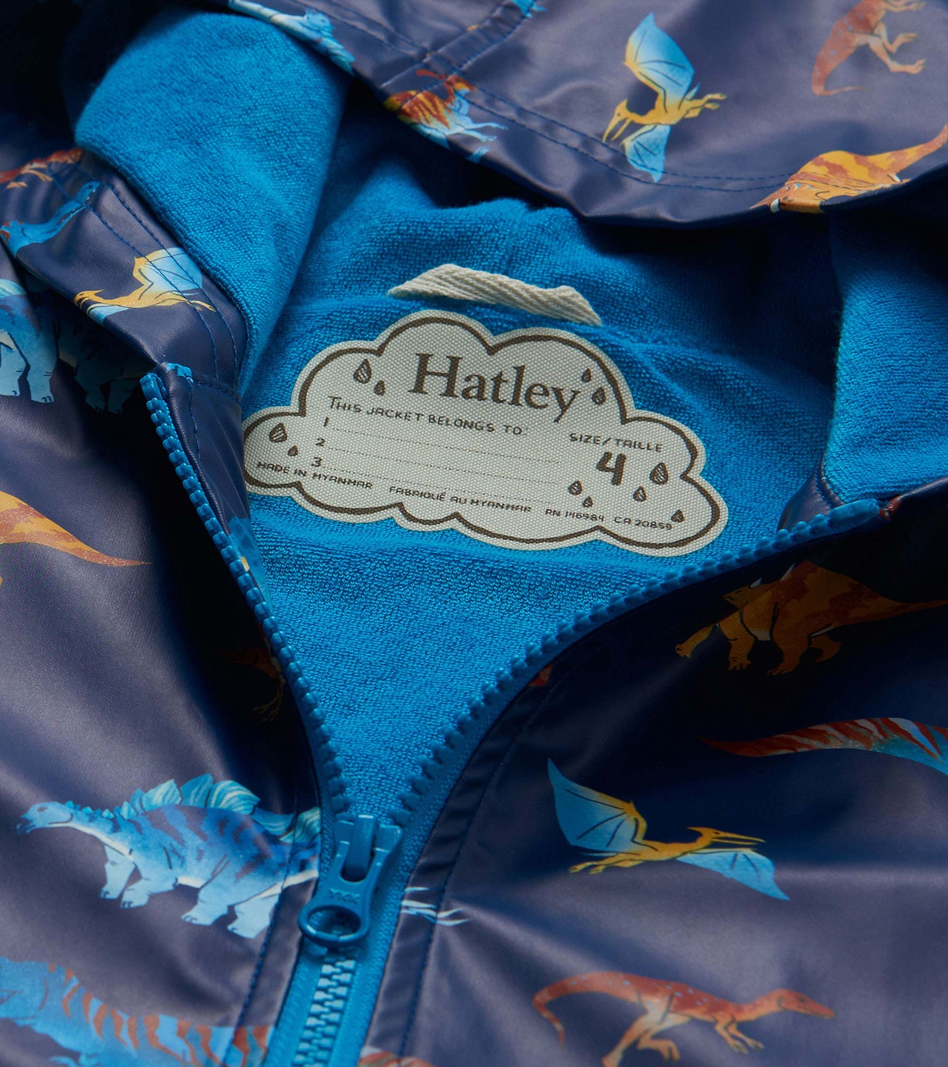 Close-up of rain coat interior with bright blue lining, zipper, and visible Hatley neck label