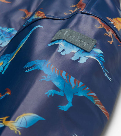 Close-up of sleeve with blue dinosaur print and raised Hatley logo patch on navy rain coat