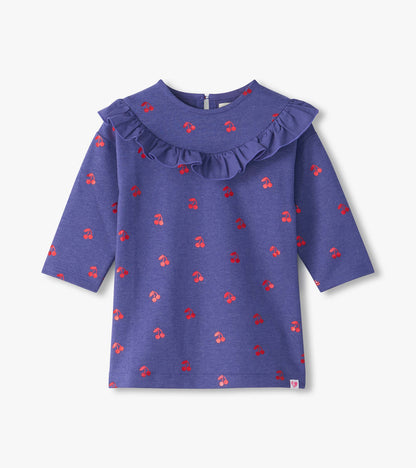 Front view of purple infant dress with red cherry print, long sleeves, and ruffle yoke