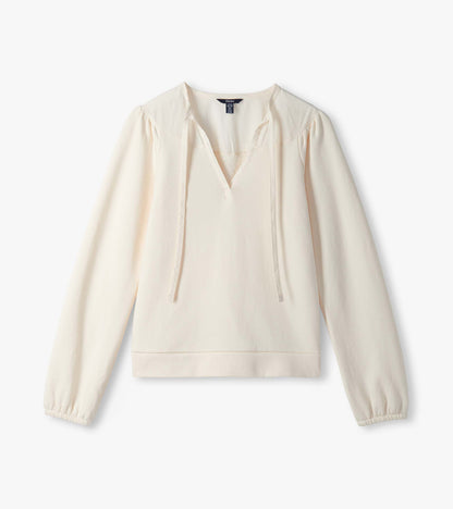 Cream long sleeve top laid flat with V neckline, tie detail, and gathered cuffs