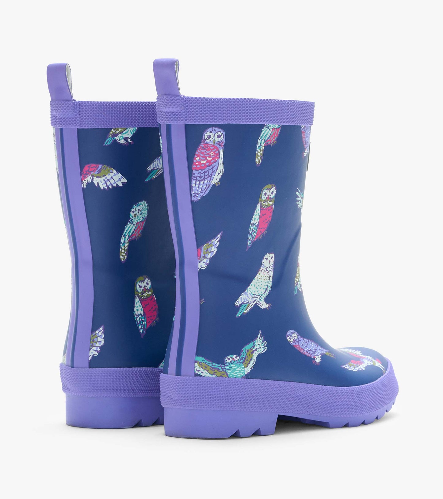 Rear side view of two navy kids rain boots with colorful owl print, purple trim, and back pull tabs