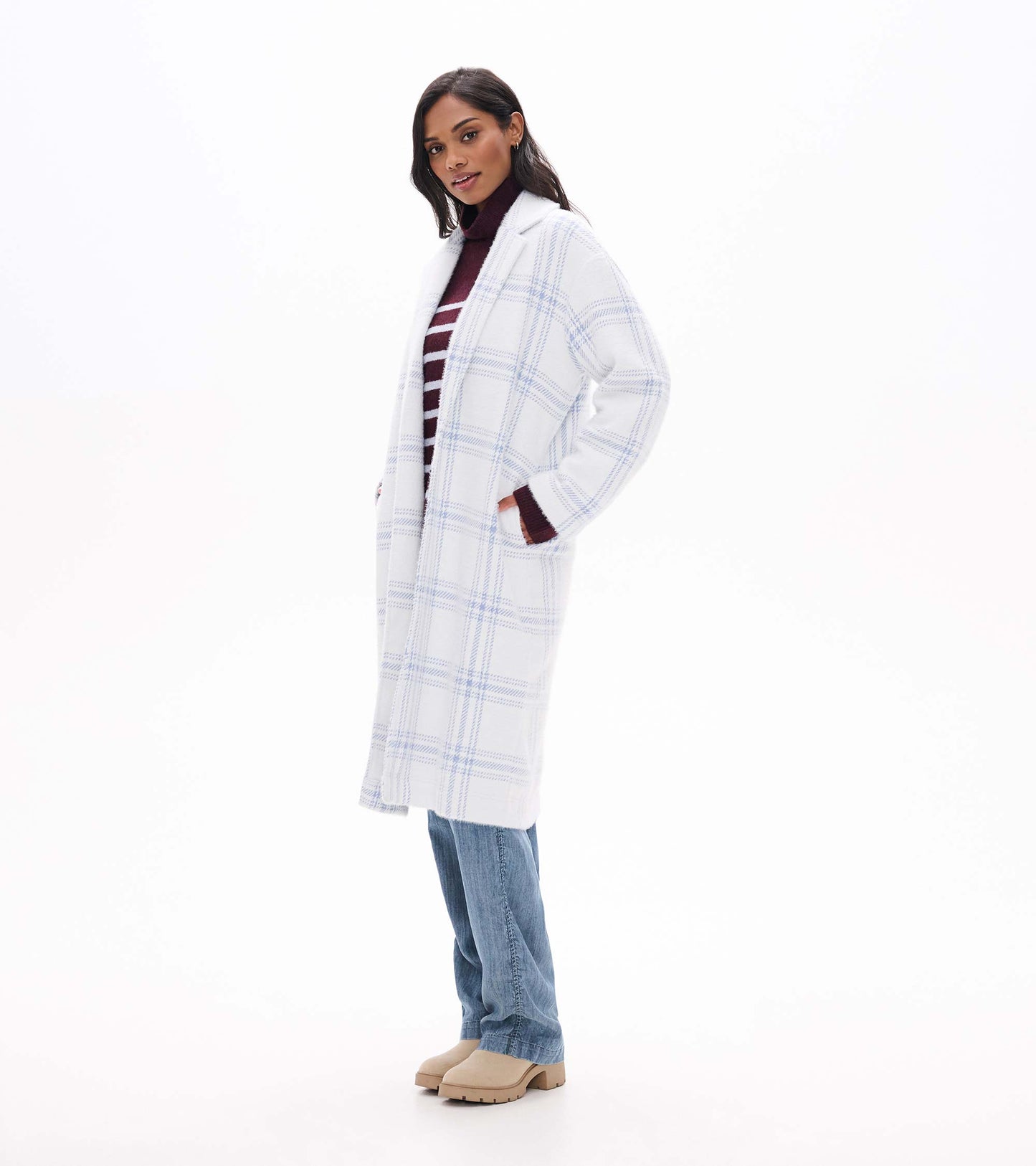 Side view of long white jacket with light blue plaid and side pockets