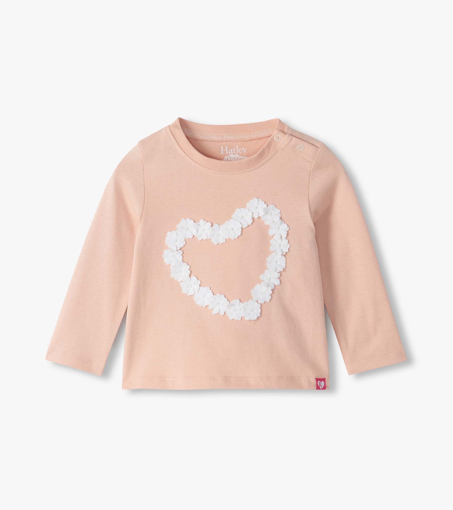 Infant blush pink long sleeve tee with shoulder snaps and a white floral heart on the front