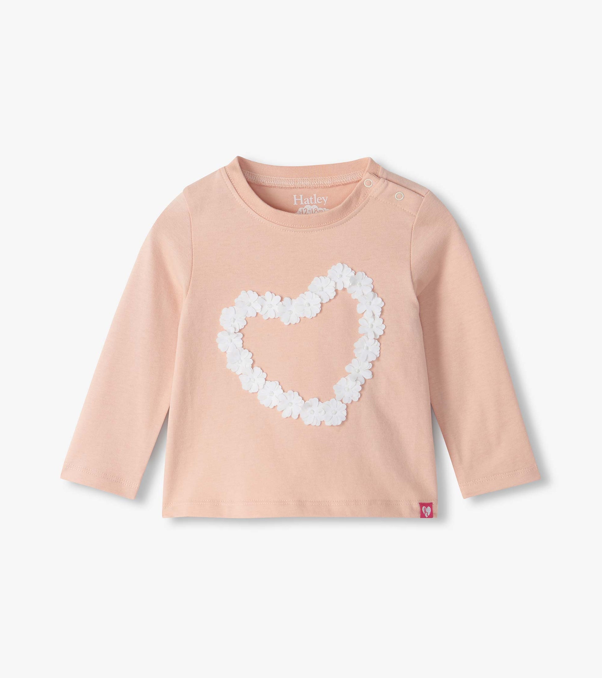 Infant blush pink long sleeve tee with shoulder snaps and a white floral heart on the front