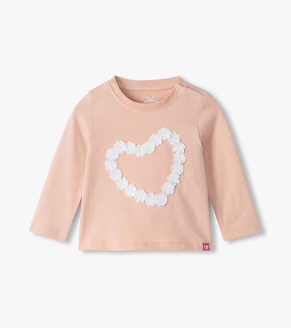 Infant blush pink long sleeve tee with shoulder snaps and a white floral heart on the front