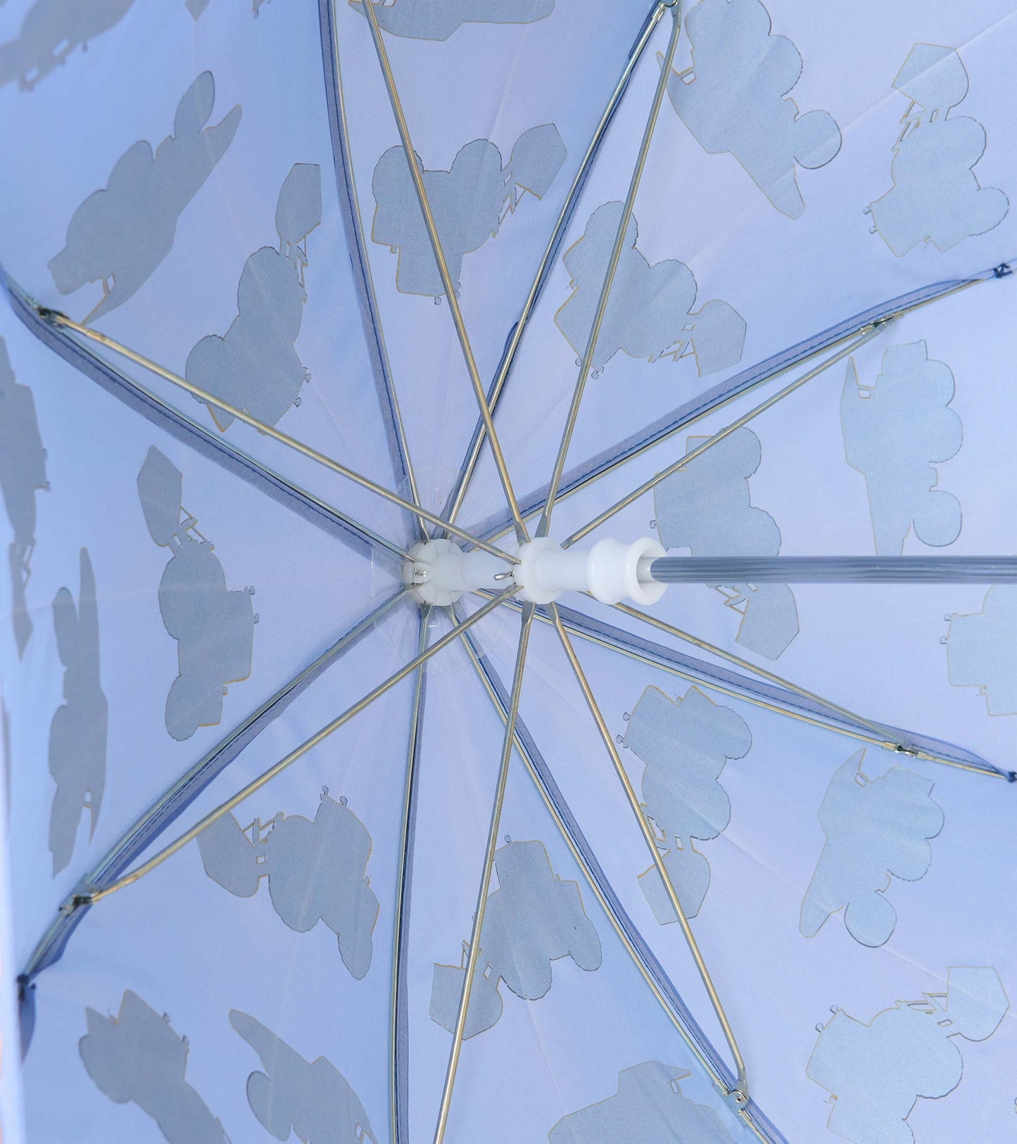 Underside of blue umbrella showing metal ribs and pale construction vehicle silhouettes