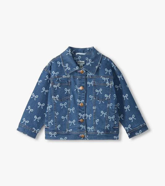 Front view of blue slouchy denim jacket with allover white bow print, chest pockets, and button front