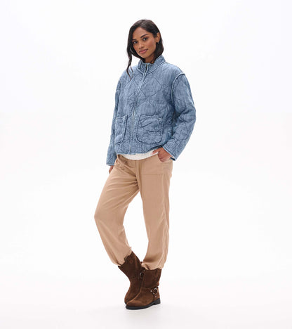 Front three-quarter view of blue acid rinse quilted jacket with stand collar and oversized patch pockets