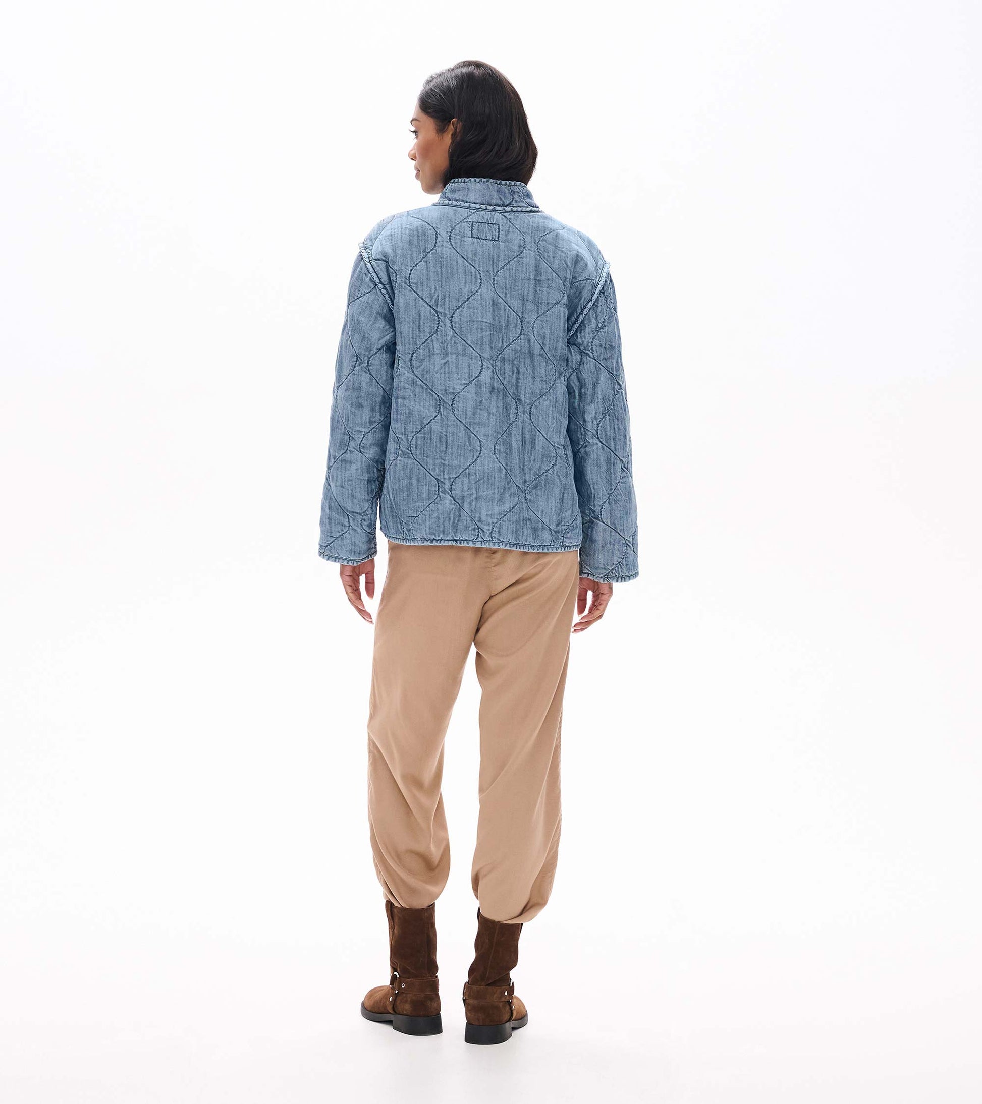 Back view of blue acid rinse quilted jacket with wavy quilted stitching and stand collar