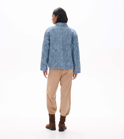Back view of blue acid rinse quilted jacket with wavy quilted stitching and stand collar