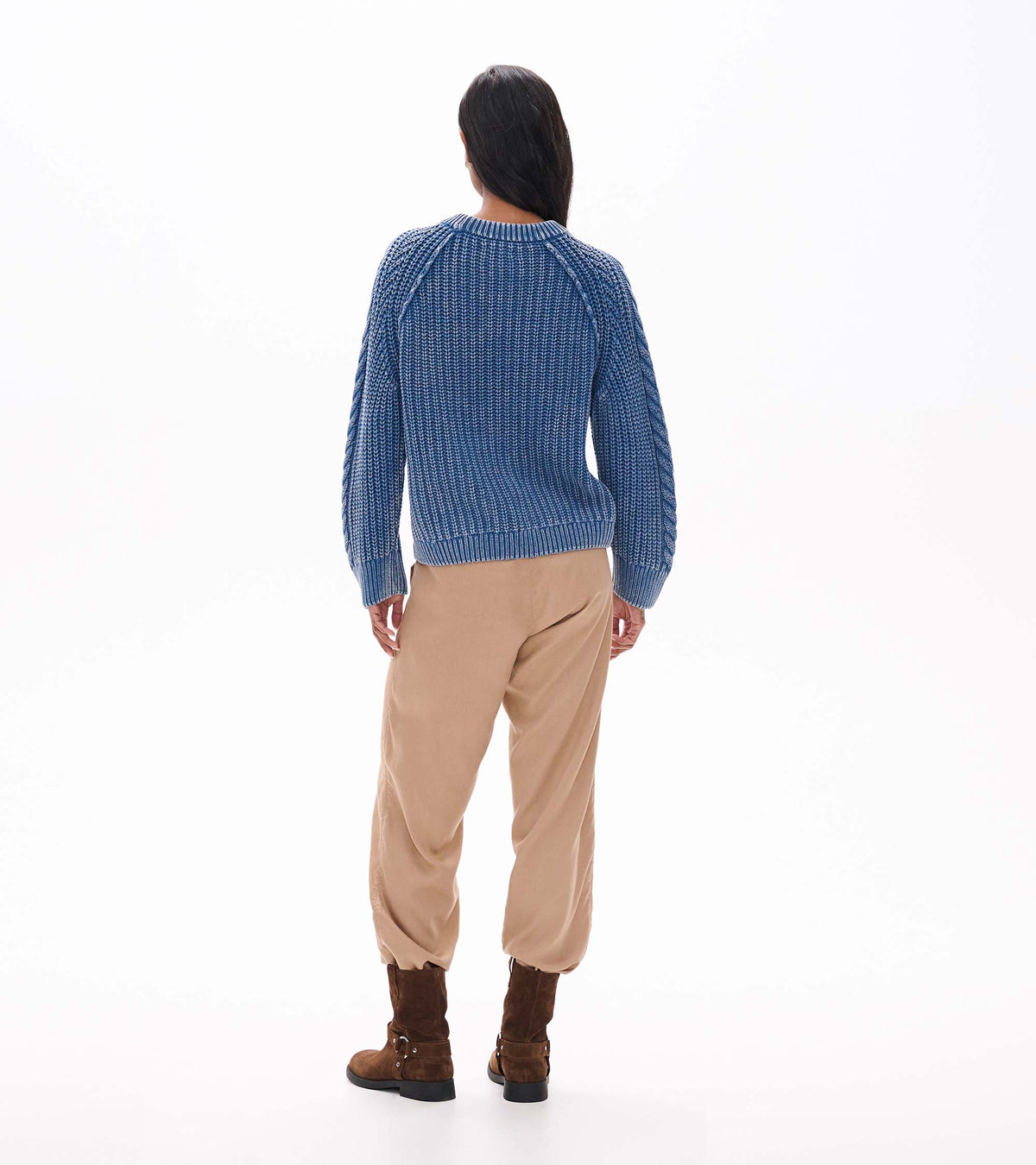 Back view of stellar blue knit sweater with ribbed hem, raglan sleeves, and cable detail on the sleeves