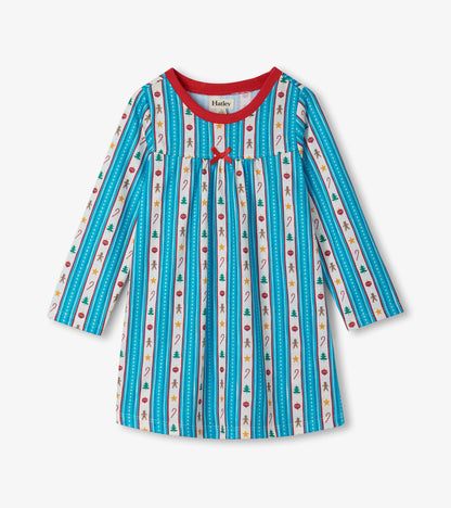 Front view of girls holiday nightdress with red neckline, red bow, and striped print with trees, candy canes, and gingerbread