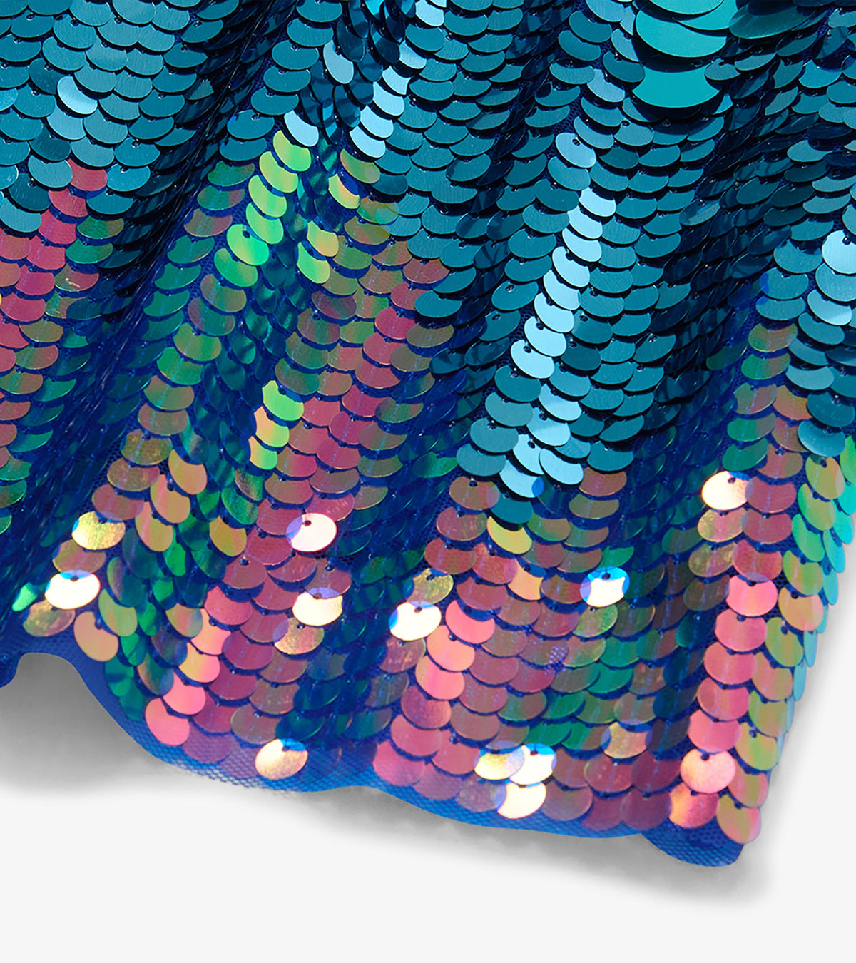 Close-up of overlapping iridescent sequins in blue, purple, pink, and green on the dress