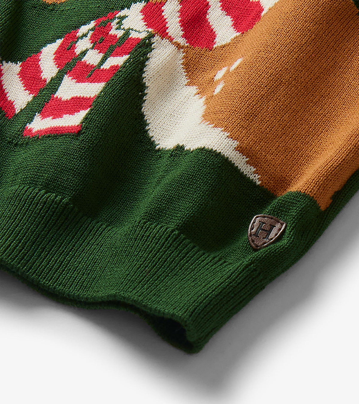 Close-up of the reindeer knit detail and ribbed hem on the forest green sweater