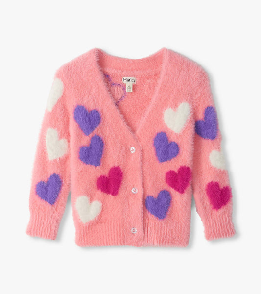 Front view of pink fuzzy cardigan with white, purple, and bright pink heart pattern and button front