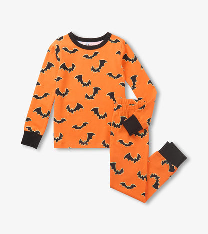 Orange kids pajama set with black bat print, black crewneck trim, and black cuffs