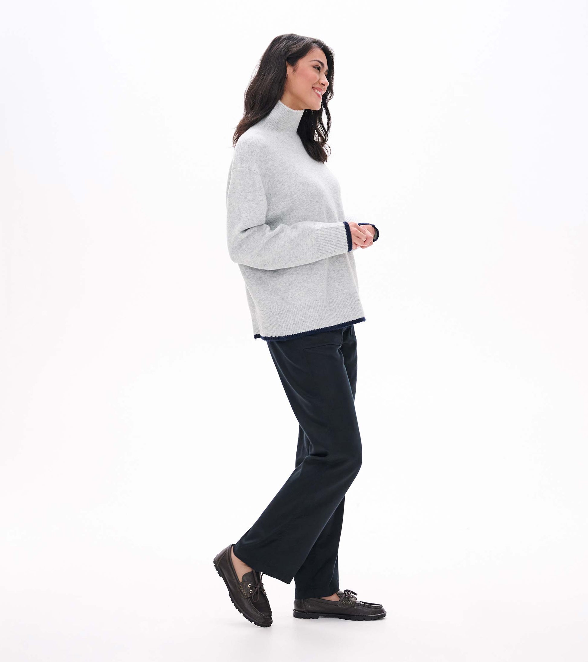 Side view of athletic grey mock neck sweater with relaxed fit and dark contrast trim at hem and cuffs