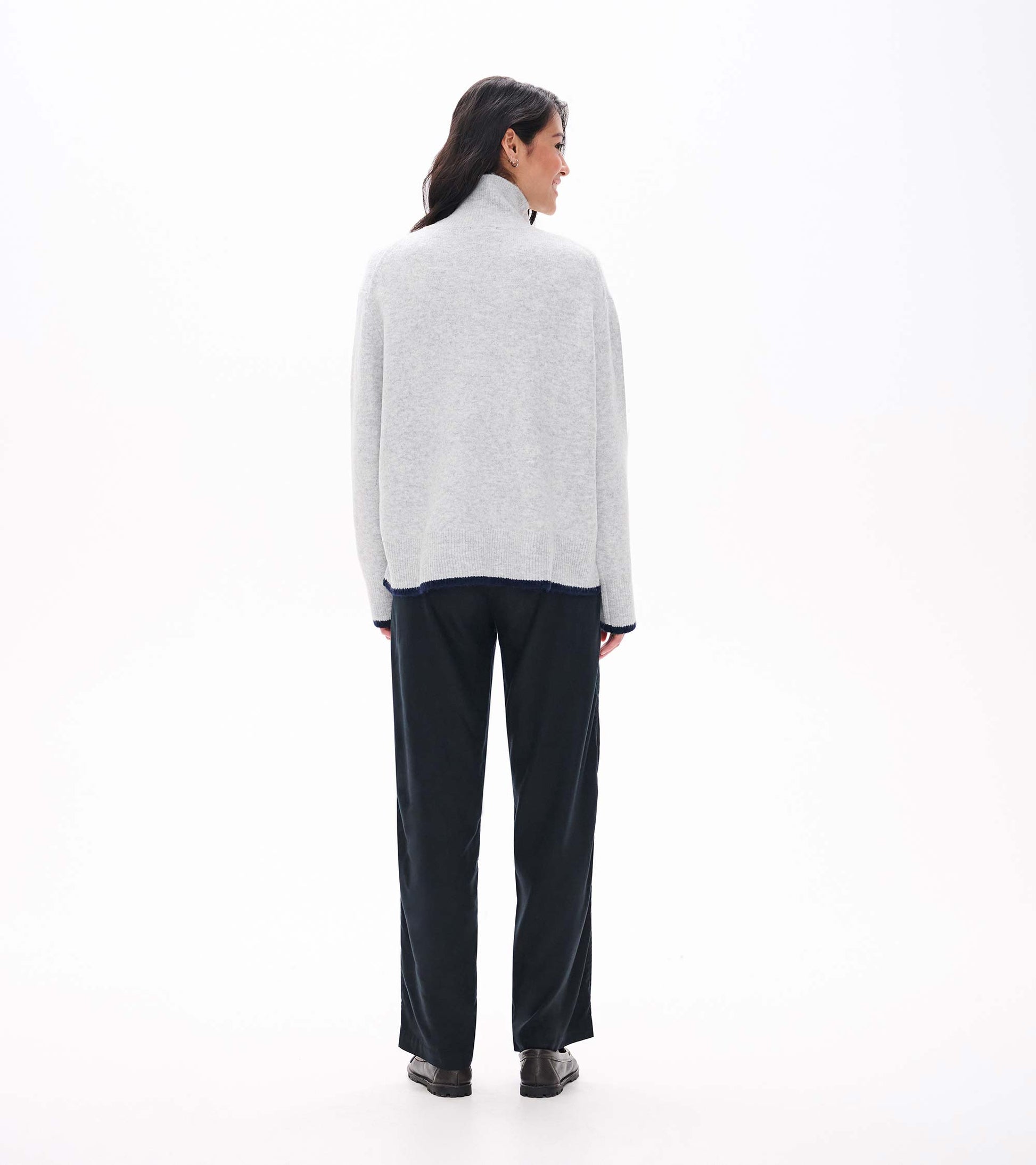 Back view of athletic grey mock neck sweater with relaxed fit and dark contrast trim at hem and cuffs