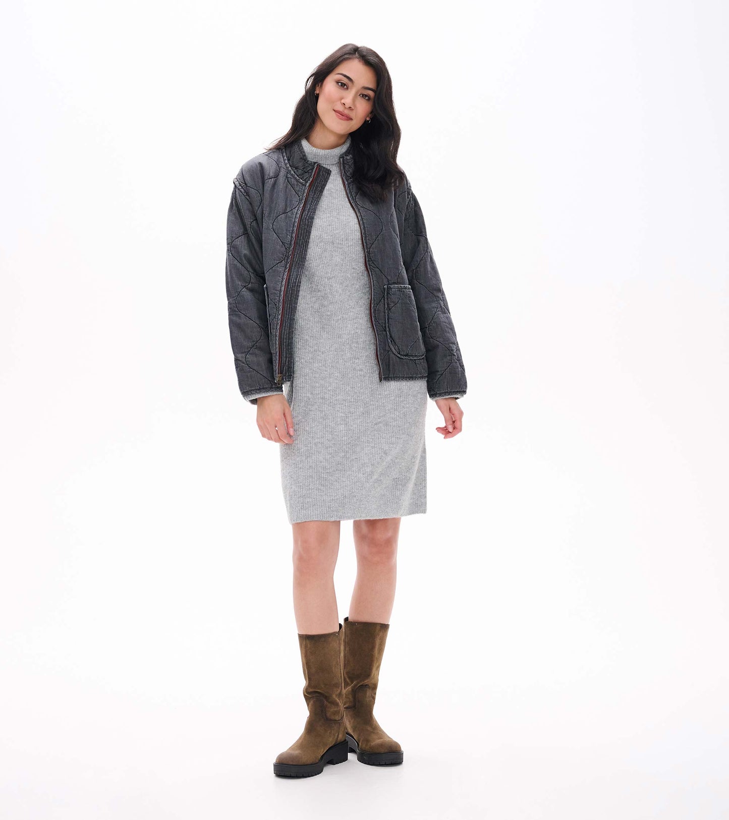 Grey melange turtleneck sweater dress layered under a dark quilted jacket, front view