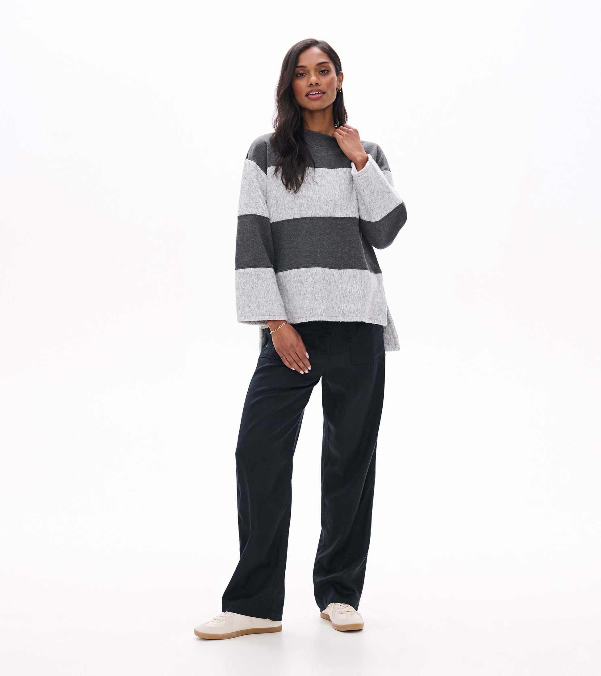 Full front view of charcoal and light gray striped top with wide sleeves and a slightly longer back hem