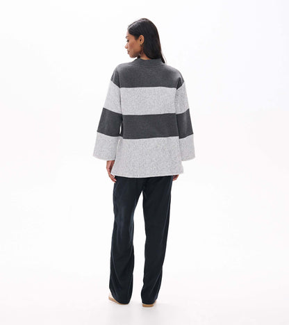 Back view of charcoal and light gray striped long sleeve top with wide sleeves and a slightly longer hem