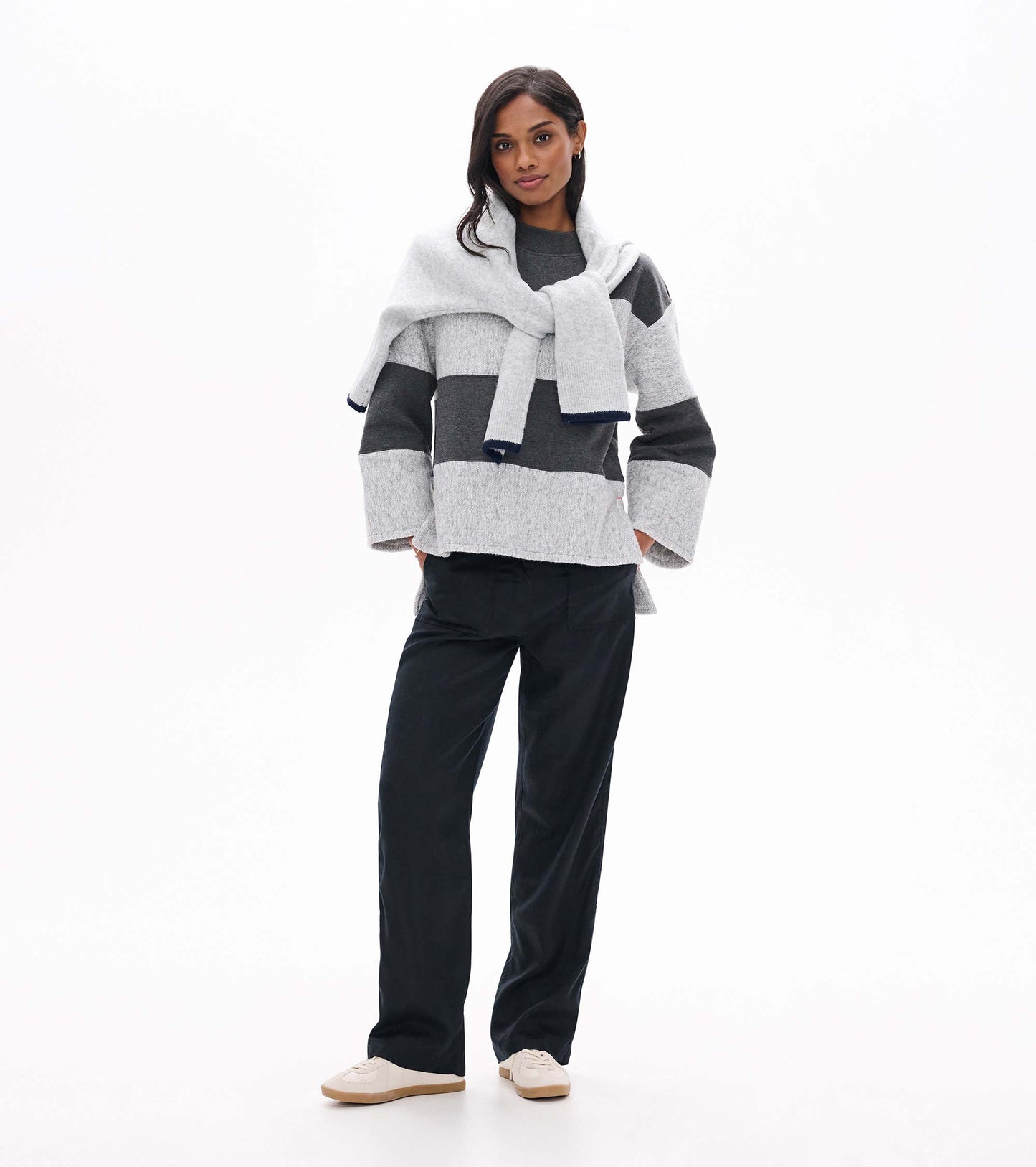 Model wearing a charcoal and light gray striped long sleeve top with a relaxed fit and wide sleeves