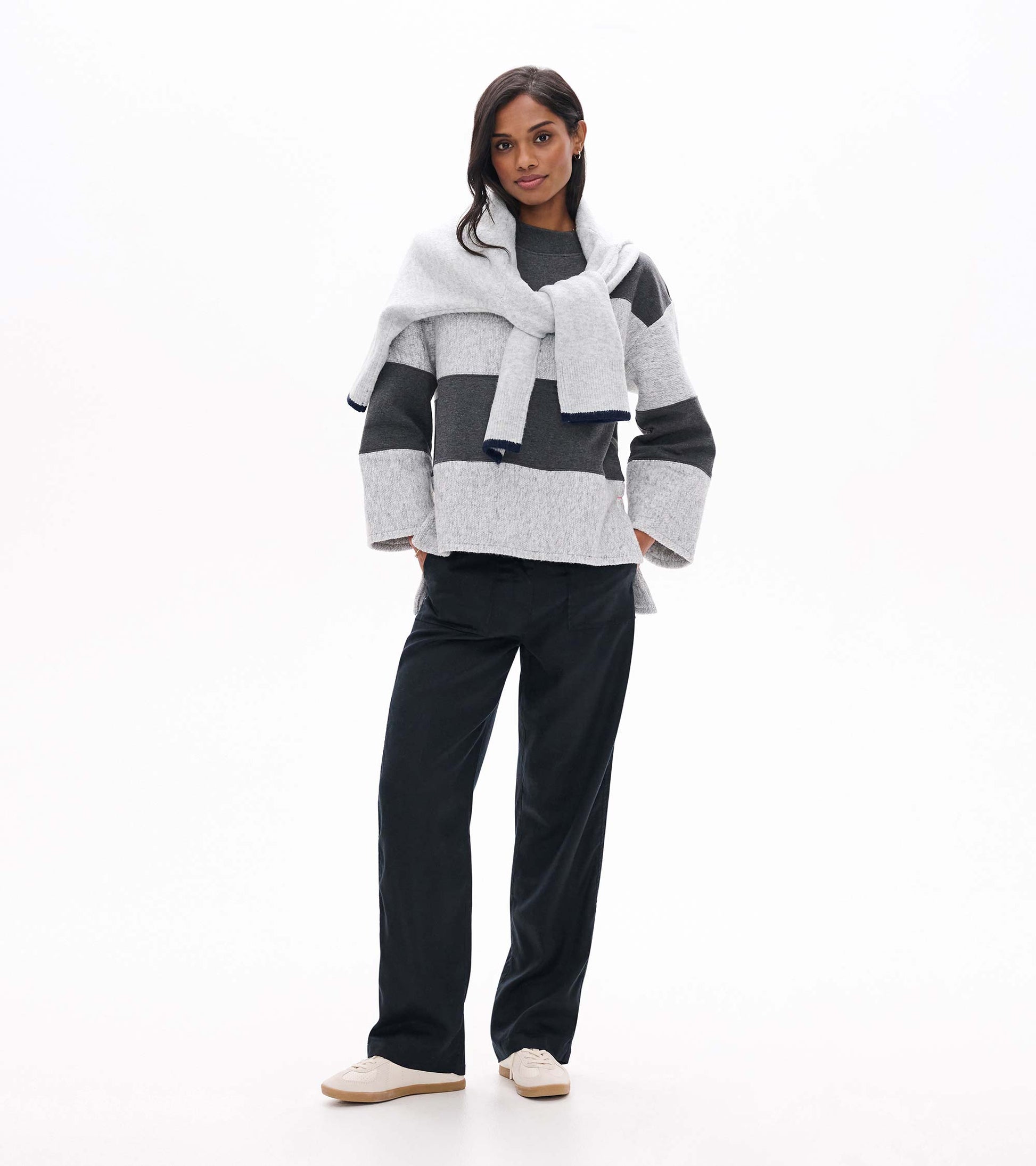 Model wearing a charcoal and light gray striped long sleeve top with a relaxed fit and wide sleeves