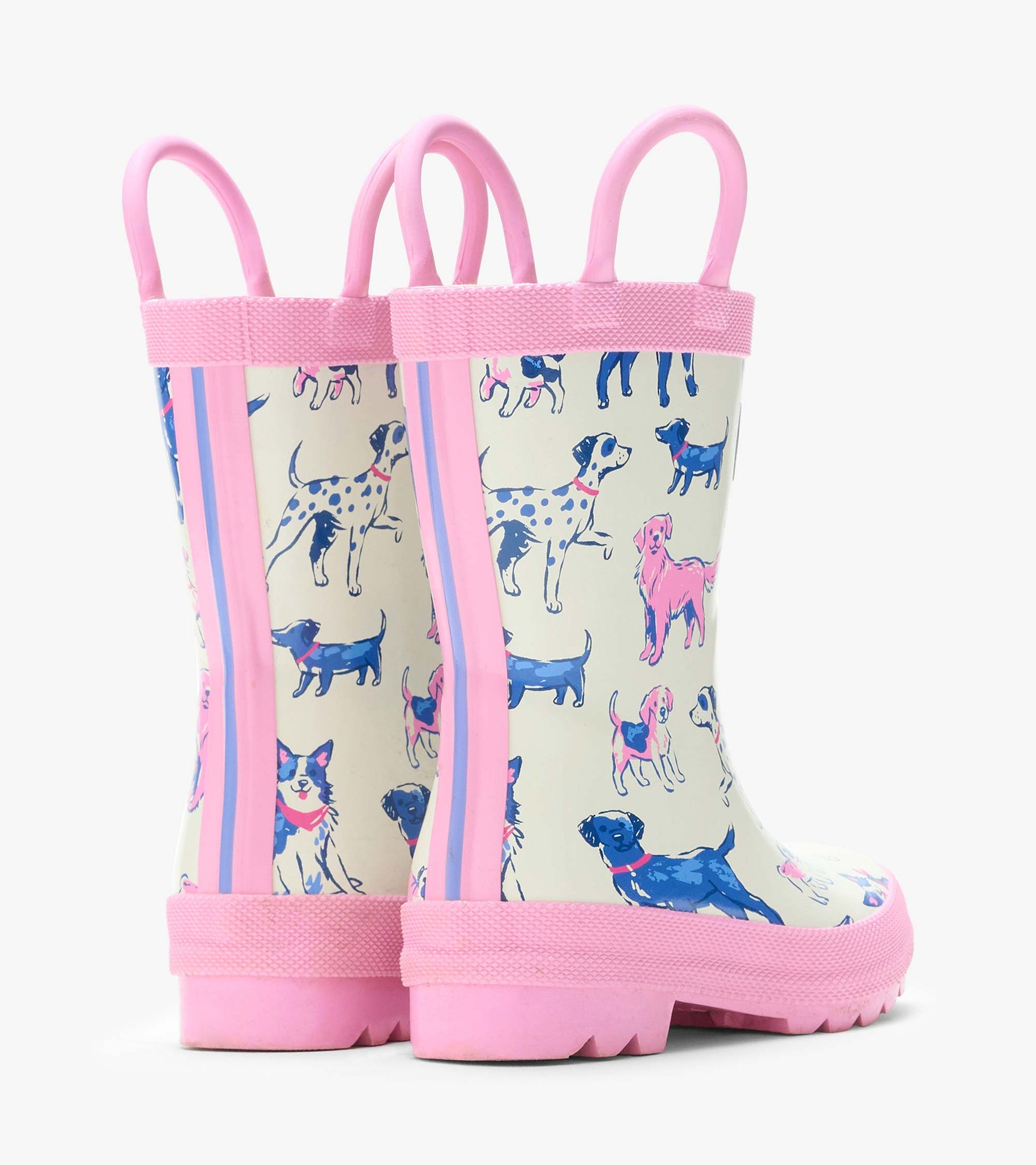 Rear angled view of cream rain boots with pink handles and trim, printed with blue and pink dogs