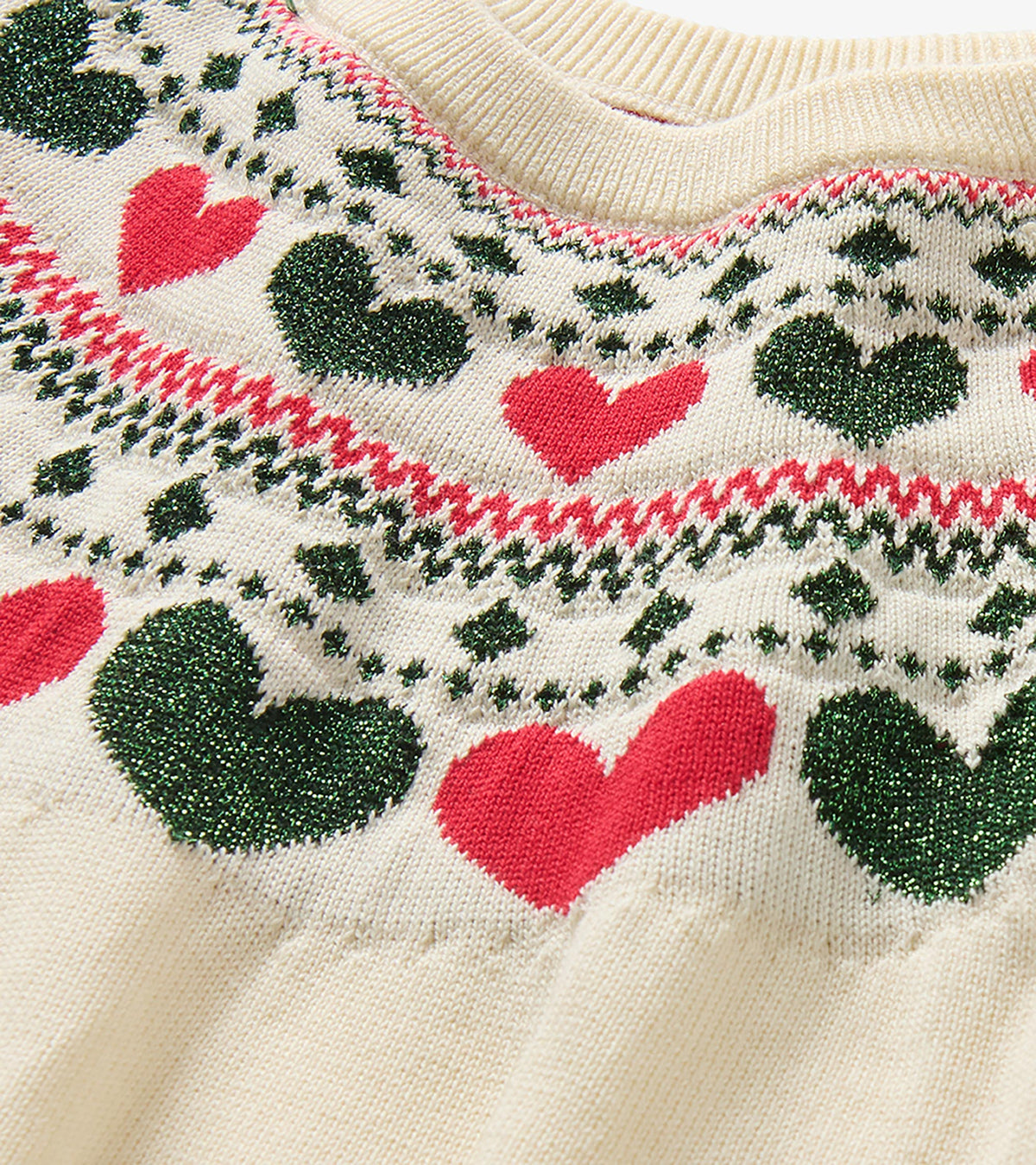 Close-up of cream knit neckline with red hearts and green heart Fair Isle-style pattern